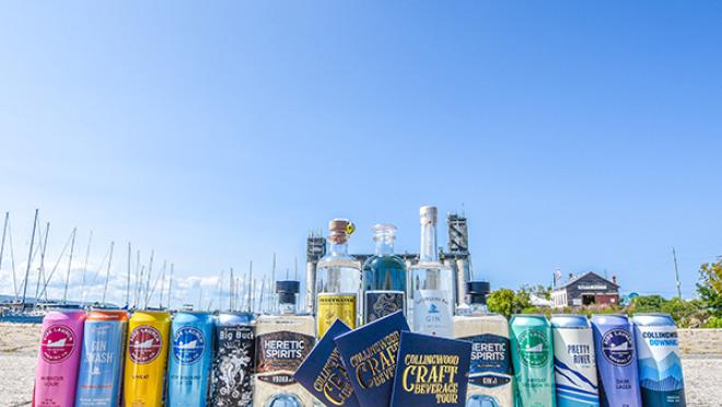 A row of several tall beer cans, with a trio of craft beer passports placed in front