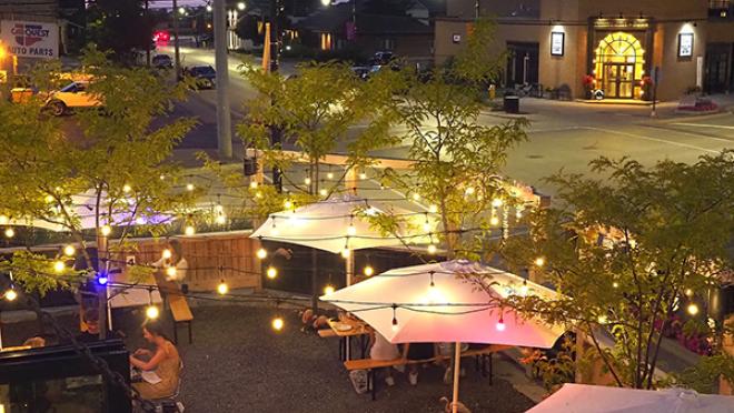 A patio in the evening, strung with lights overhead