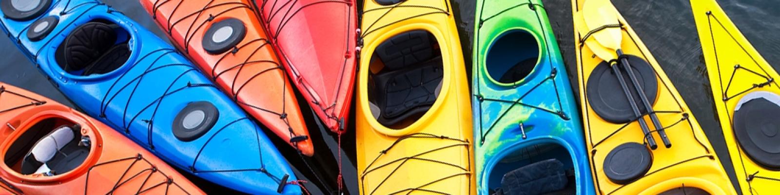 Different coloured kayaks next to each other